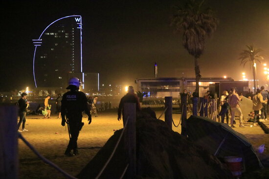Police breaking up a large crowd at a Barcelona beach (by Laura Fíguls)